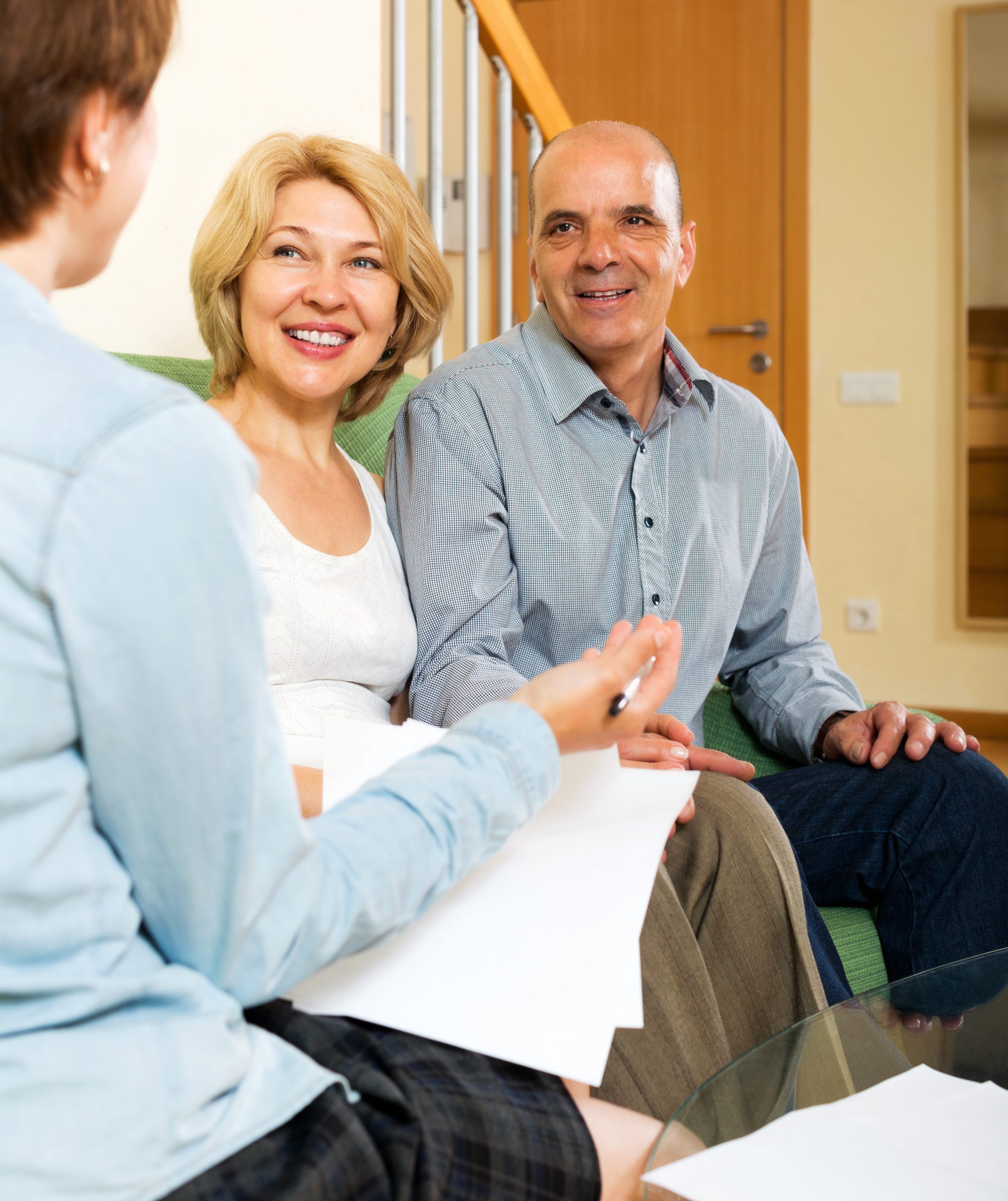 Happy  elderly  couple discussing details of private insurance with agent